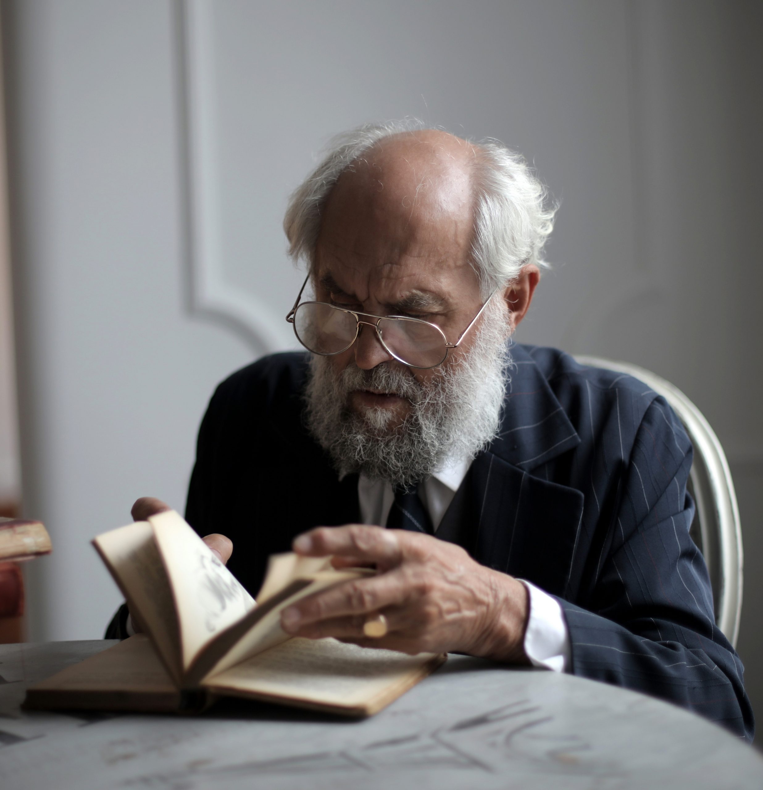 view-old-caucasian-male-reading-antique-book-room-1